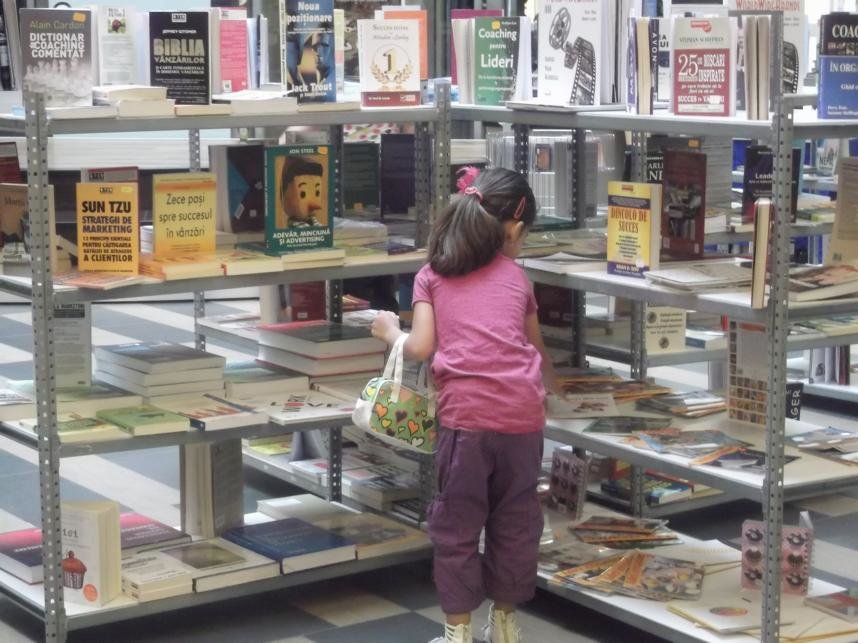 o fetiță atrasă de cărțile din Caravana BookLand 